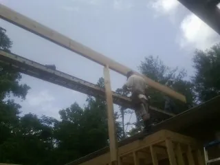 Carpenter setting a ridge beam over a new addition frame — Ice Dam Removal by Roofing Brothers in Chimney Rock