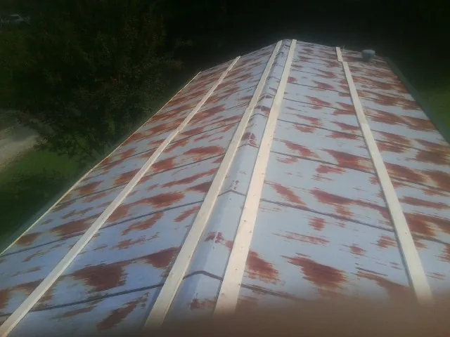 Rusted metal roof panels with new wood purlins before replacement — Storm Damage Roof Repair in Chimney Rock by Roofing Brothers