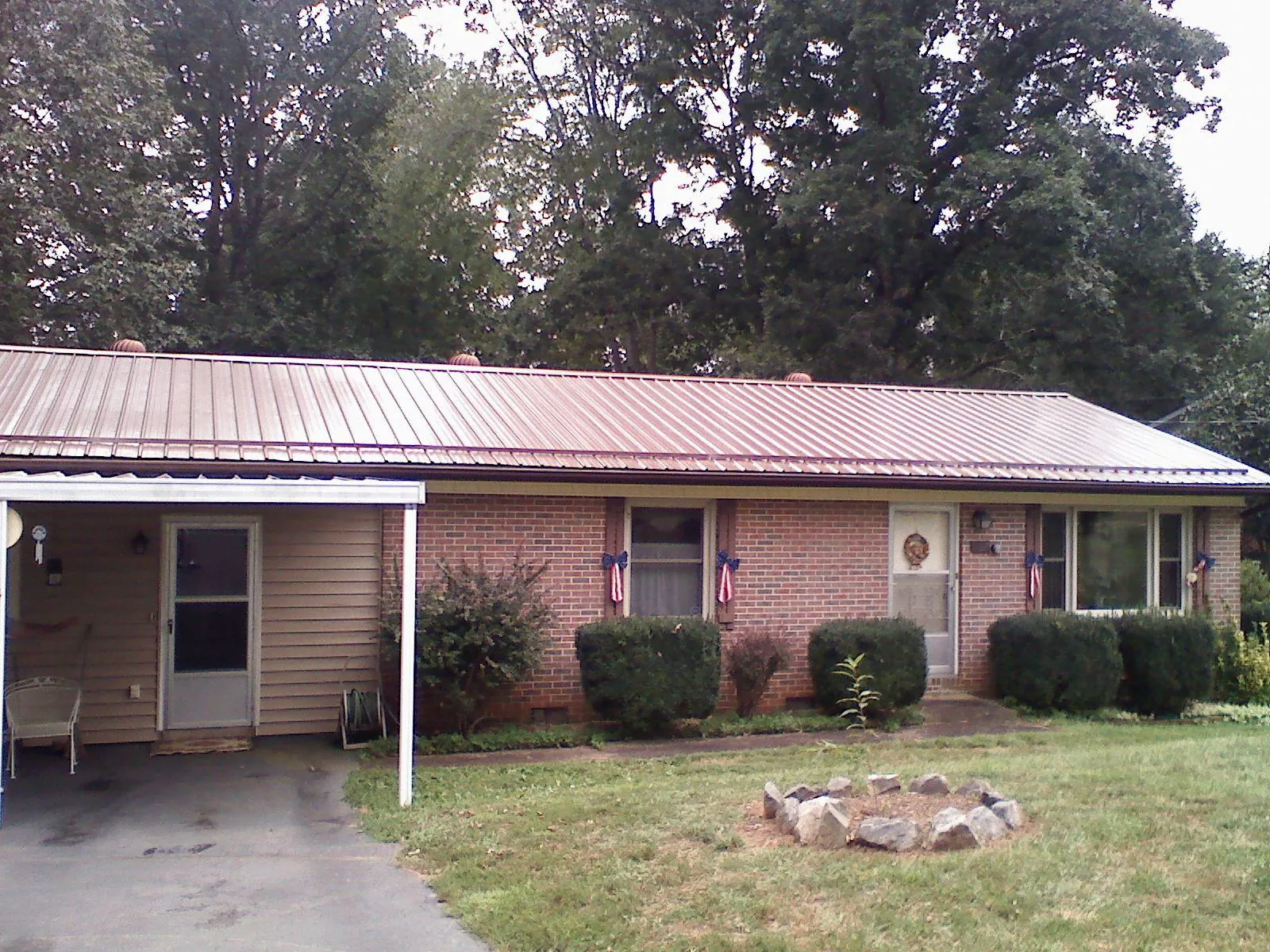 Bronze metal roof and carport on a brick ranch home — Roof Repair work by our crew in Chimney Rock